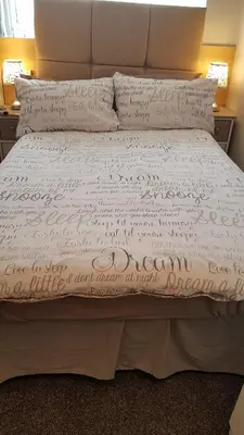 a bed with a white comforter and pillows at Somerset House Apartments in Blackpool