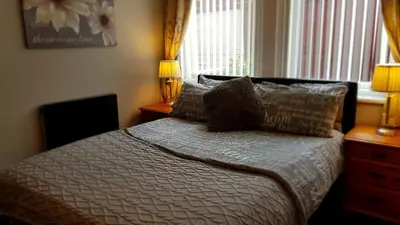 a bedroom with a bed with pillows and a window at Somerset House Apartments in Blackpool