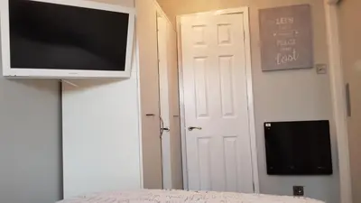 a flat screen tv hanging on a wall next to a door at Somerset House Apartments in Blackpool