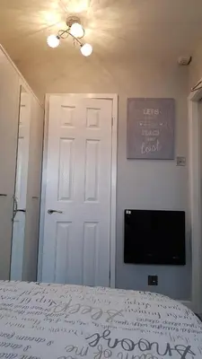 a bedroom with a white door and a tv at Somerset House Apartments in Blackpool