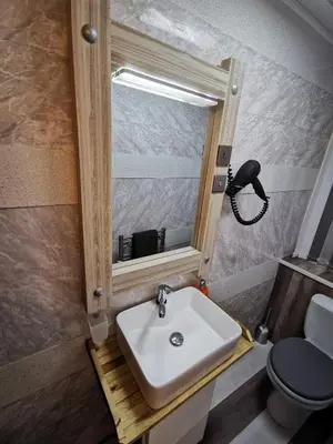 a bathroom with a sink and a toilet and a mirror at Somerset House Apartments in Blackpool
