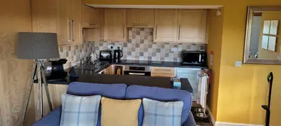 a kitchen with a blue couch in front of a counter at no 7 boutique apartment in Ulverston