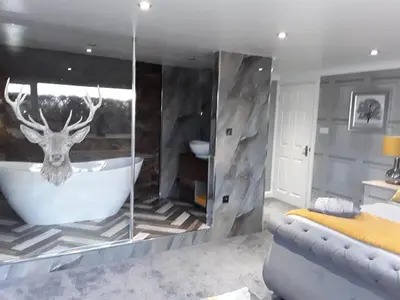 a bathroom with a tub with a deer head on the wall at no 7 boutique apartment in Ulverston