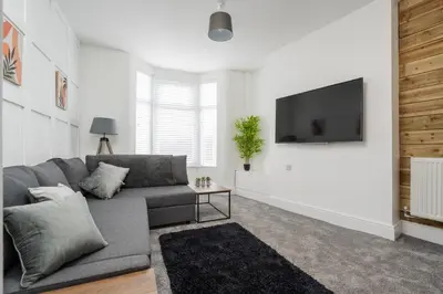 a living room with a couch and a flat screen tv at HARROW LODGE - Strictly NO Parties in Liverpool