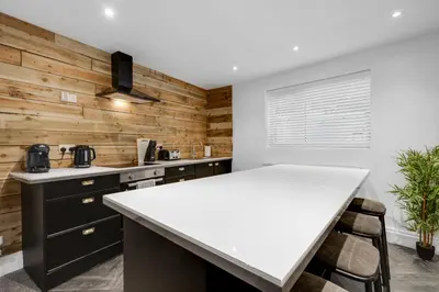 a kitchen with wooden walls and a white counter top at HARROW LODGE - Strictly NO Parties in Liverpool