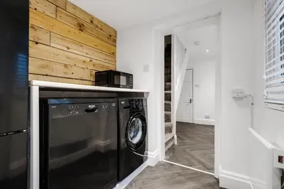 a washer and dryer in a room with a wooden wall at HARROW LODGE - Strictly NO Parties in Liverpool