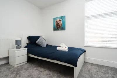 a bedroom with a blue bed and a window at HARROW LODGE - Strictly NO Parties in Liverpool