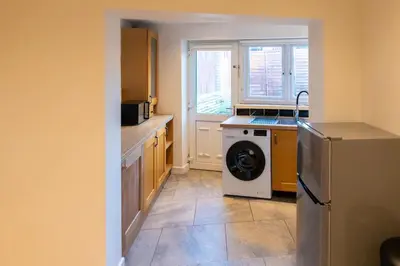 a kitchen with a refrigerator and a dishwasher at Modern cottage WiFi Free Parking in Penwortham
