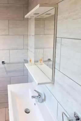 a white bathroom with a sink and a mirror at Modern cottage WiFi Free Parking in Penwortham