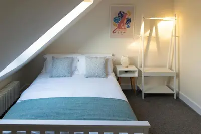 a bedroom with a white bed and a ladder at Modern cottage WiFi Free Parking in Penwortham