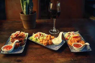 a table with three plates of food and a glass of wine at The Wellsprings Lodges and Restaurant in Clitheroe