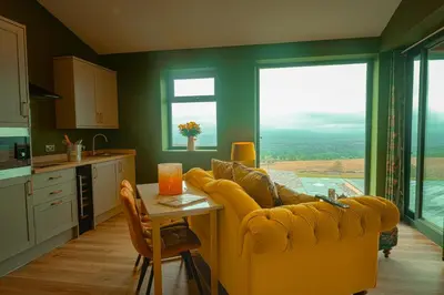 a living room with a yellow couch and a table at The Wellsprings Lodges and Restaurant in Clitheroe