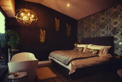 a bedroom with a bed and a bath tub at The Wellsprings Lodges and Restaurant in Clitheroe