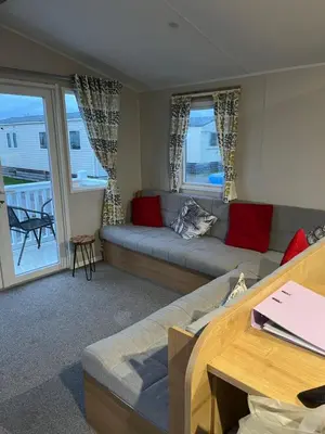 a living room with a couch and a table at Lorraine's Caravan Holiday in Morecambe