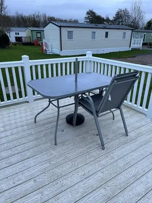 a table and a chair on a deck at Lorraine's Caravan Holiday in Morecambe