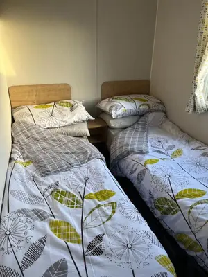 two beds sitting next to each other in a room at Lorraine's Caravan Holiday in Morecambe