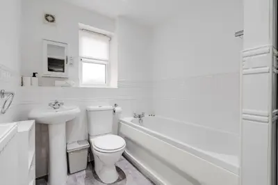 a white bathroom with a toilet and a sink at The Point , 2 Bed, Parking - Pass the Keys in Knowsley