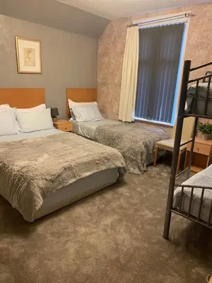 a bedroom with two beds and a window at Chaplins in Blackpool