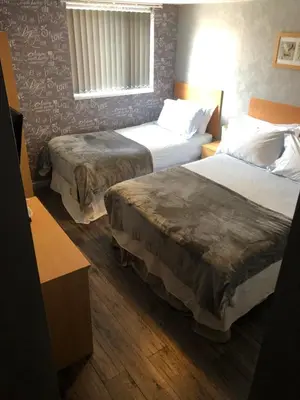 a hotel room with two beds and a window at Chaplins in Blackpool
