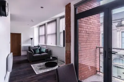 a living room with a couch and a brick wall at Central Liverpool 1 Bed Apartment w Balcony in Liverpool