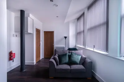 a living room with a couch and some windows at Central Liverpool 1 Bed Apartment w Balcony in Liverpool