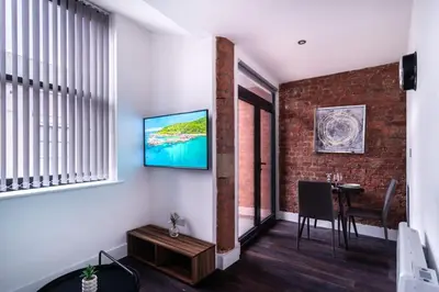 a living room with a television on a wall at Central Liverpool 1 Bed Apartment w Balcony in Liverpool