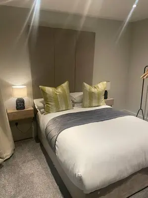 a bedroom with a large bed with yellow pillows at 1 Bed Apt - Balcony - City View - Great Location in Liverpool