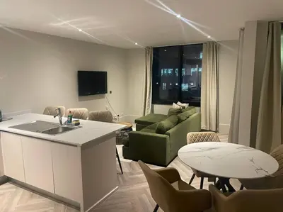 a kitchen and living room with a couch and a table at 1 Bed Apt - Balcony - City View - Great Location in Liverpool