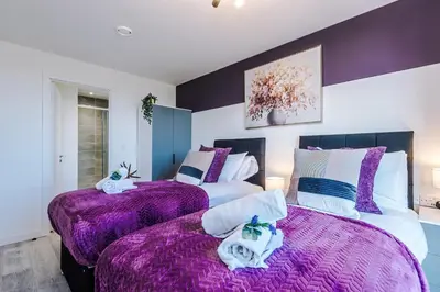 two beds in a bedroom with purple blankets at NEW! Stunning 2-bed apartment in Liverpool by 53 Degrees Property - Amazing location, Ideal for Small Groups - Sleeps 4! in Liverpool