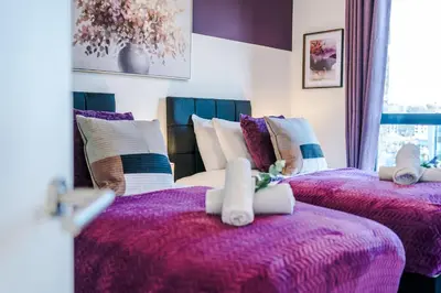 two beds in a room with purple blankets and pillows at NEW! Stunning 2-bed apartment in Liverpool by 53 Degrees Property - Amazing location, Ideal for Small Groups - Sleeps 4! in Liverpool