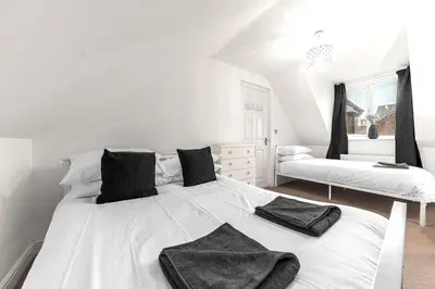 a bedroom with a white bed with black towels on it at ML Short Stays - Barrow House 4 bedrooms in Roose