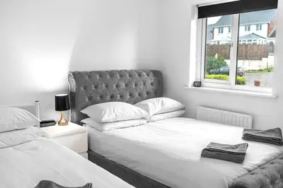 a bedroom with two beds and a window at ML Short Stays - Barrow House 4 bedrooms in Roose