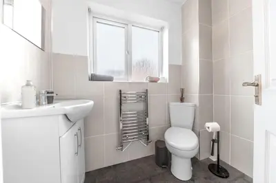 a white bathroom with a toilet and a sink at ML Short Stays - Barrow House 4 bedrooms in Roose
