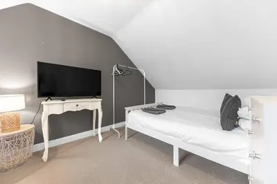 a bedroom with a bed and a desk with a television at ML Short Stays - Barrow House 4 bedrooms in Roose