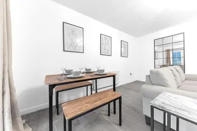 a living room with a table and a couch at ML Short Stays - Barrow House 4 bedrooms in Roose