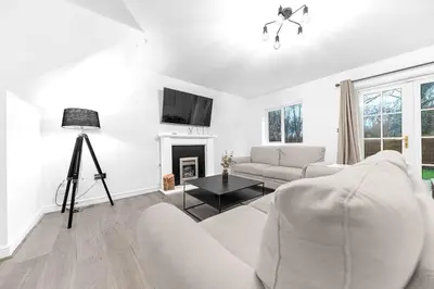a white living room with a white couch and a fireplace at ML Short Stays - Barrow House 4 bedrooms in Roose