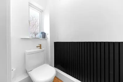 a white bathroom with a toilet and a window at ML Short Stays - Barrow House 4 bedrooms in Roose