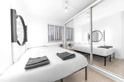 a white bedroom with two beds and a mirror at ML Short Stays - Barrow House 4 bedrooms in Roose