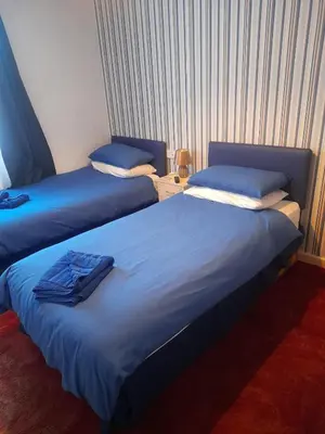 a room with two beds with blue sheets at Lynton Hotel in Blackpool
