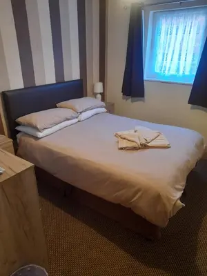 a bed with two towels on it in a bedroom at Lynton Hotel in Blackpool