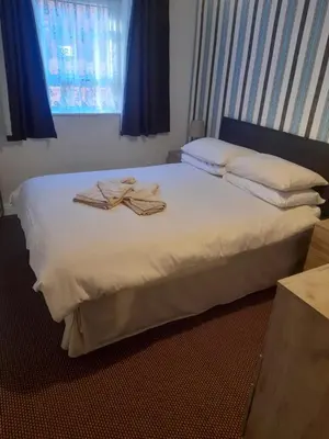 a bedroom with a bed with two towels on it at Lynton Hotel in Blackpool