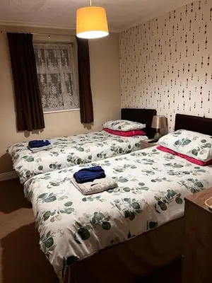 two beds in a bedroom with a bedspread with towels on it at Lynton Hotel in Blackpool
