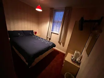 a small bedroom with a bed and a window at Lynton Hotel in Blackpool