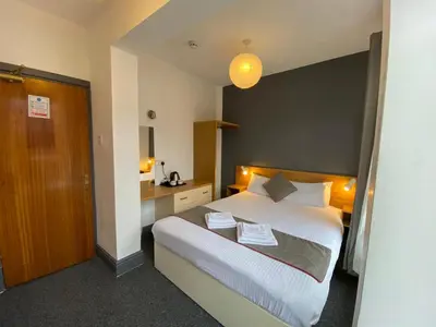 a hotel room with a bed and a bathroom at Alumhurst Hotel in Blackpool