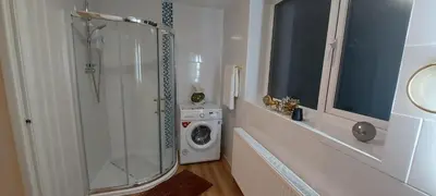 a bathroom with a shower and a washing machine at OLIVE TREE - 2 Master bedroom (sleeps 6) in Blackpool