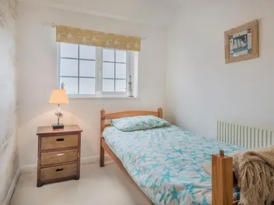 a bedroom with a bed and a nightstand and a window at 3 Bed in Baycliff SZ130 in Baycliff