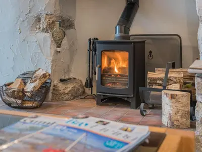 a wood fired stove in a room with a table at 3 Bed in Baycliff SZ130 in Baycliff