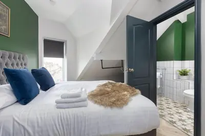 a bedroom with a large bed with blue and green walls at Ettie and Gigi's in Blackpool