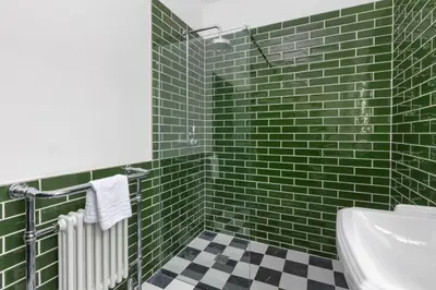 a green tiled bathroom with a sink and a toilet at Ettie and Gigi's in Blackpool