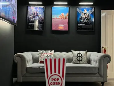 a living room with a couch and four movie posters at Now Screening…Large Movie Place 60 Inch TV (Sleep 11) in Liverpool